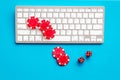 Gambling, online games. Chips and dices near keyboard on blue background top-down