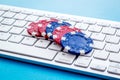 Gambling, online games. Chips near keyboard on blue background