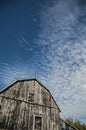 Gambrel roof black weathered barn with deep blue sky and cloudscapes