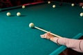 game of billiards the hand of woman with a billiard cue aims at a billiard ball Royalty Free Stock Photo