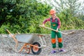 Game of builder and construction. Outdoor activity concept. girl who is transporting rubble in a wheelbarrow Royalty Free Stock Photo