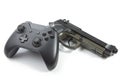 Game controller and a real handgun near it - studio shot. Virtual and real life concept Royalty Free Stock Photo