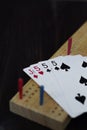Playing cards and cribbage board on black background Royalty Free Stock Photo
