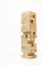 A game of logic and the ability to think. Jenga tower with wooden blocks on a white background. The tower is half