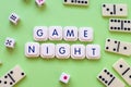 Game night words made with board game letters, on a green background, surrounded by dice and dominoes Royalty Free Stock Photo