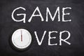 Game over text written with white chalk on chalkboard or blackboard.Time is over concept