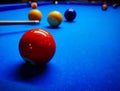 Game of pool with multiple balls and pool cue focus on a single ball Royalty Free Stock Photo