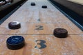 Game of Shuffleboard on wooden table with pucks and salt Royalty Free Stock Photo