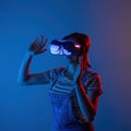 The game vr.The girl in the helmet and with the controller plays a game with creative light