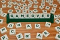 Gameover word made up of letter tiles surrounded by letters. Woden Table Royalty Free Stock Photo