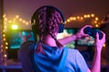 Gamer girl with a joystick plays on a console or computer using a gamepad, controller, joystick. Against the background of three Royalty Free Stock Photo