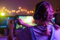 Gamer girl with a joystick plays on a console or computer using a gamepad, controller, joystick. Against the background of three Royalty Free Stock Photo