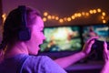 Gamer girl with a joystick plays on a console or computer using a gamepad, controller, joystick. Against the background of three Royalty Free Stock Photo