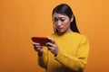 Gamer girl upset because of lost online game played online on smartphone device.