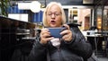 Gamer grandma playing on the smartphone loses the game