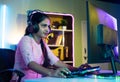 gamer seriously playing live video game on computer with headphones at home - concept of live streamer, vlogger and Royalty Free Stock Photo