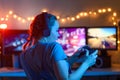 A gamer or a streamer girl at home in a dark room with a gamepad playing with friends on the networks in video games. A young man Royalty Free Stock Photo