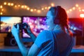 A gamer or a streamer girl at home in a dark room with a gamepad playing with friends on the networks in video games. A young man Royalty Free Stock Photo