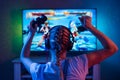 A gamer or a streamer girl at home in a dark room with a gamepad playing with friends on the networks in video games. A young man Royalty Free Stock Photo