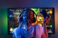 A gamer or a streamer girl at home in a dark room with a gamepad playing with friends on the networks in video games. A young man Royalty Free Stock Photo