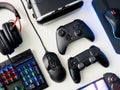 Gamer workspace concept, top view a gaming gear, mouse, keyboard, joystick, headset and mouse pad on white table background.