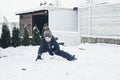 Games in the snow, winter holidays, family vacations. Cute caucasian boy playing in the snow in the yard of the house Royalty Free Stock Photo