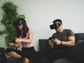 Gaming concept, A couple playing video games wearing virtual reality glasses in their apartment - Cheerful people having fun with
