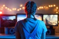 Gaming and e-sports. A streamer girl plays games using the joystick and gamepad. On three monitors, creative light Royalty Free Stock Photo