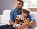 Gaming, father and son on a sofa, playing and loving at home, quality time and bonding. Family, dad or male child on a Royalty Free Stock Photo