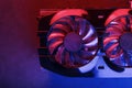 Gaming graphics card with neon magenta-cyan illumination and high-speed fans. Royalty Free Stock Photo