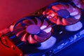 Gaming graphics card with neon magenta-cyan illumination and high-speed fans. Royalty Free Stock Photo