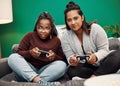 Gaming isnt just for the guys. two young women playing video games on the sofa at home. Royalty Free Stock Photo