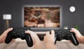 Gaming in living room concept. Two boys holding gamepad and play console game on TV