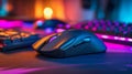 Gaming mouse with programmable buttons and rgb lighting on a desk with a backlit keyboard in a vibrant colorful gaming setup Royalty Free Stock Photo