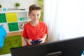 Boy with gamepad playing video game on computer Royalty Free Stock Photo