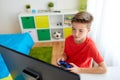 Boy with gamepad playing video game on computer Royalty Free Stock Photo