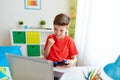 Boy with gamepad playing video game on laptop Royalty Free Stock Photo