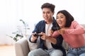 Excited Asian Couple Playing Videogames Sitting On Couch At Home Royalty Free Stock Photo