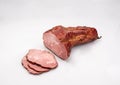 Gammon, smoked ham - in one piece and sliced, isolated on a white background. Polish cold cuts, a packshot photo. Royalty Free Stock Photo