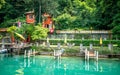 Pier and people in middle of green nature and Grotto Descanso restaurant sign at Cantine di Gandria Switzerland