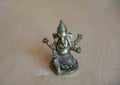 Ganesha`s gilded figure on a light background