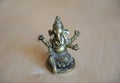 Ganesha`s gilded figure on a light background