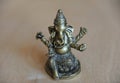 Ganesha`s gilded figure on a light background