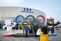 Gangneung, Gangwon province, South Korea - A group of foreign tourists posing for a picture with the Olympic flag and mascots.