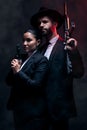 Gangster couple, fashion or gun on studio background in secret spy, isolated mafia safety or crime lord security. Man Royalty Free Stock Photo