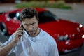 Gangster, criminal concept. Angry man near car on night urban street. Dangerous aggressive man with serious face Royalty Free Stock Photo