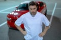 Gangster, criminal concept. Angry man near car on night urban street. Dangerous aggressive man with serious face Royalty Free Stock Photo