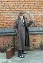 Gangster holding a rifle gun, posing outdoors.