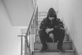 Gangster sitting on stairs, alone with his thoughts and his guns