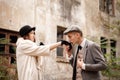 Gangsters. Against the background of an abandoned building in the forest, a man kisses a woman`s hand.